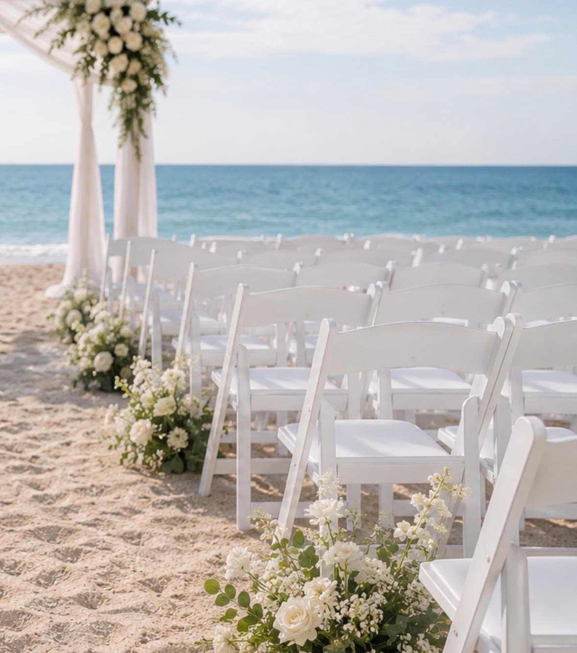 White folding chairs arranged for a wedding ceremony